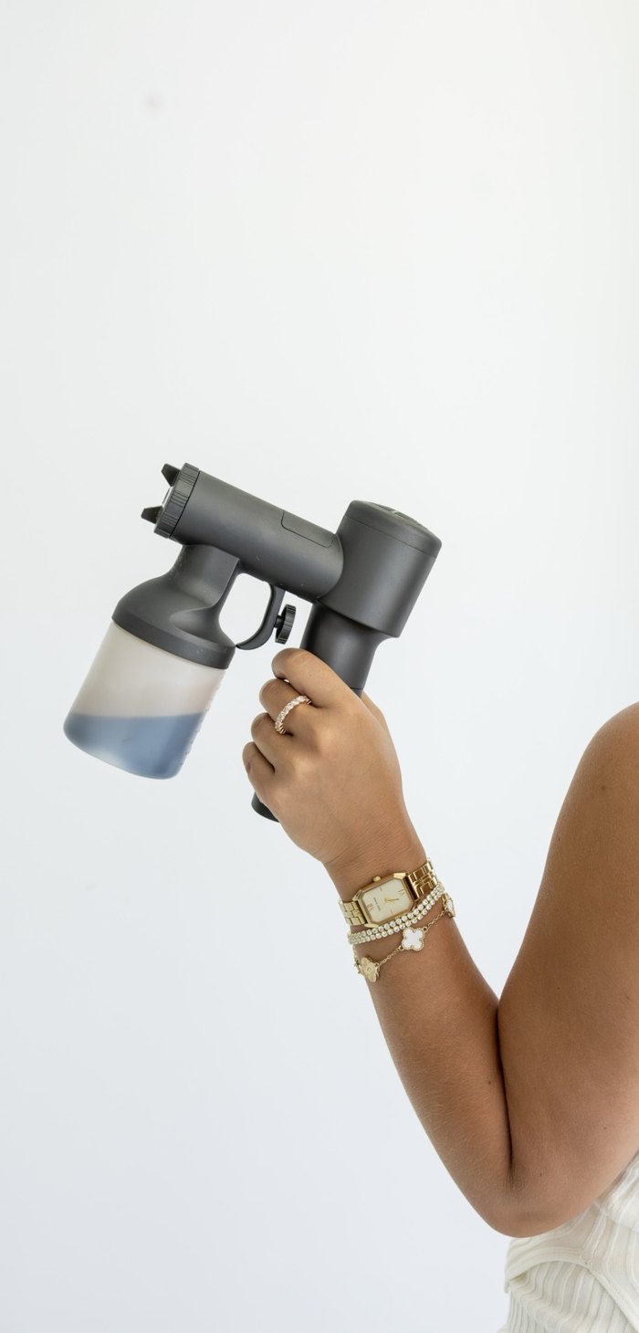 Kylie holding a spray tan gun